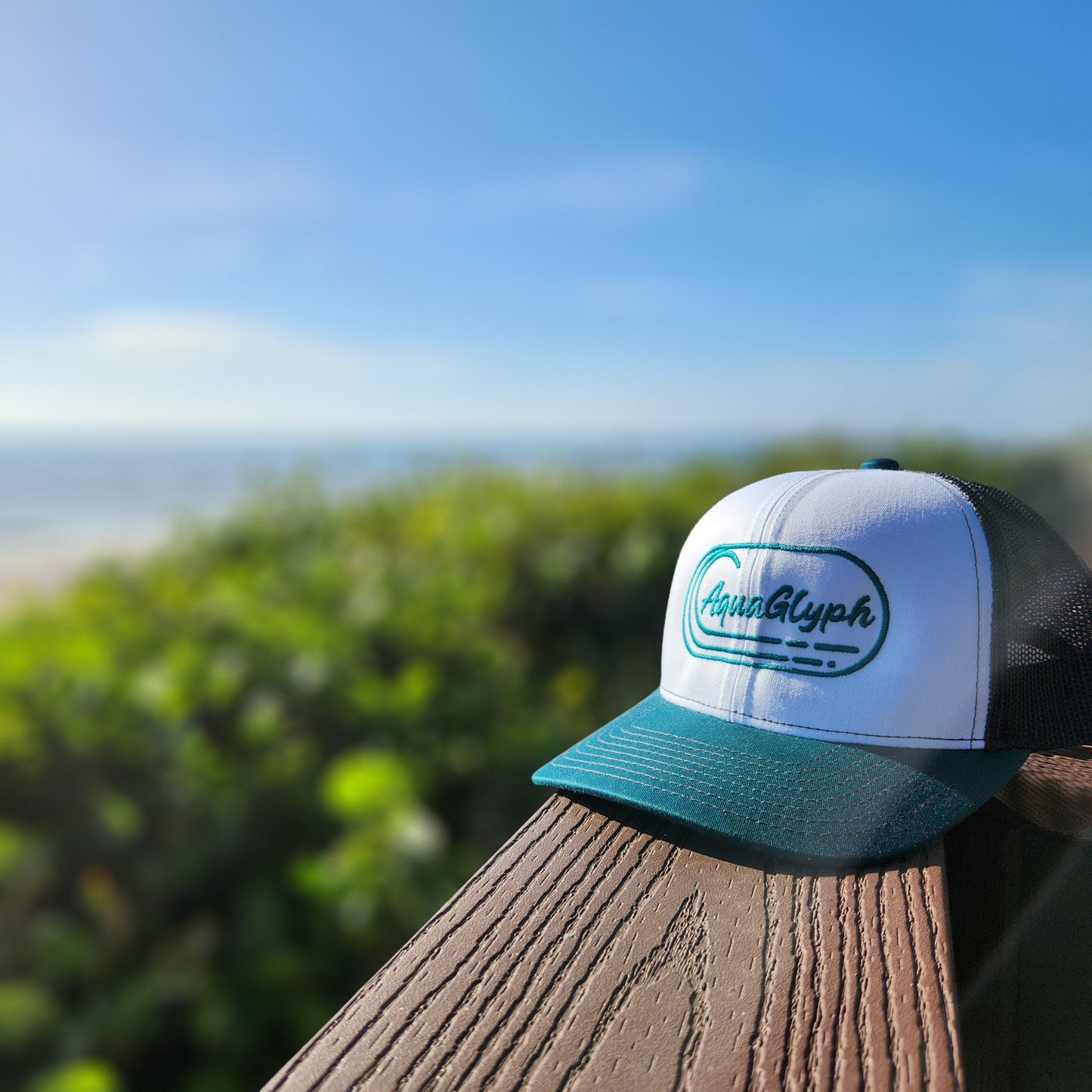 AquaGlyph Peacock Logo Trucker Hat